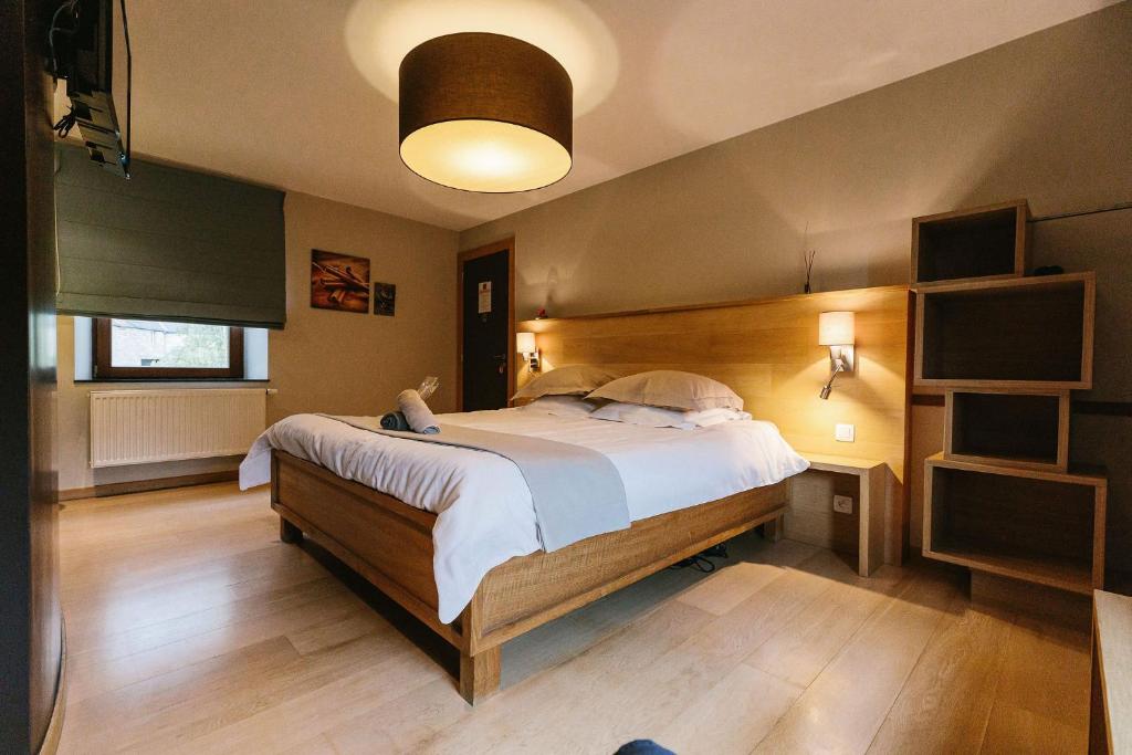 法拉恩爱杰彼百利住宿加早餐酒店的一间卧室配有一张大床和木制床头板