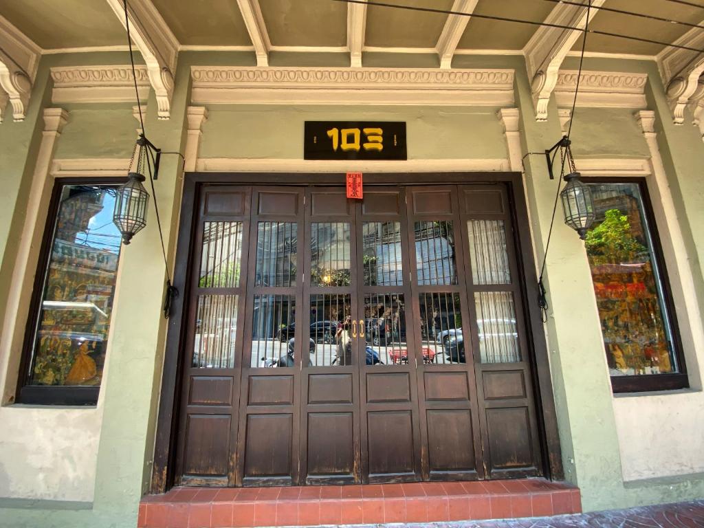 曼谷布鲁斯103号酒店的建筑物的前门,上面有时钟