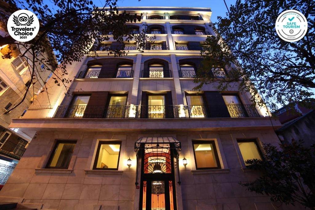 伊斯坦布尔The Fox Hotel的一座高大的建筑,晚上有灯光的外墙