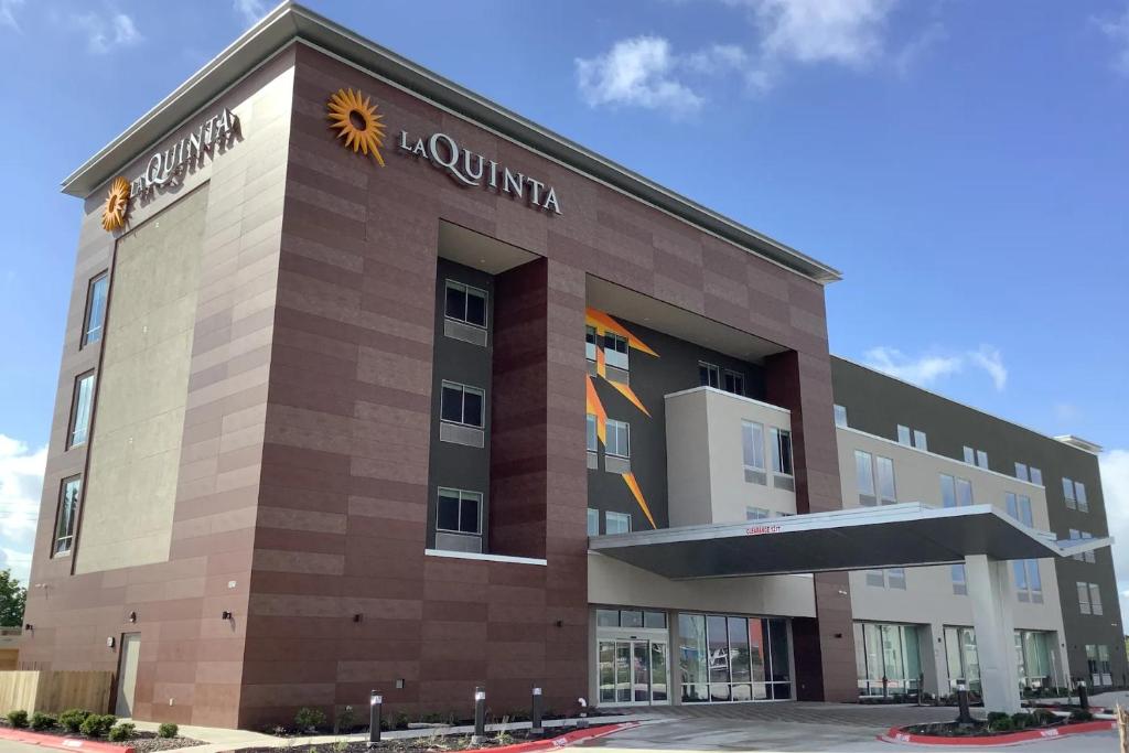 科珀斯克里斯蒂La Quinta Inn & Suites by Wyndham Corpus Christi Southeast的前面有太阳标志的建筑