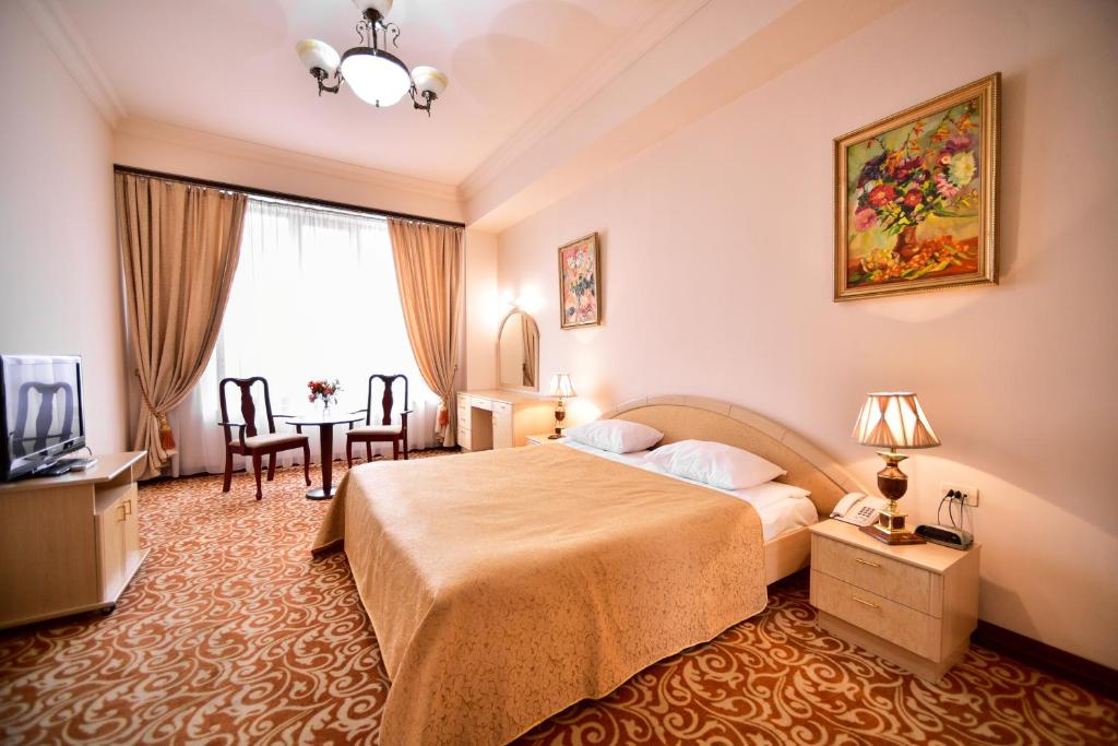 埃里温METROPOL HOTEL Yerevan的酒店客房配有一张床铺和一张桌子。