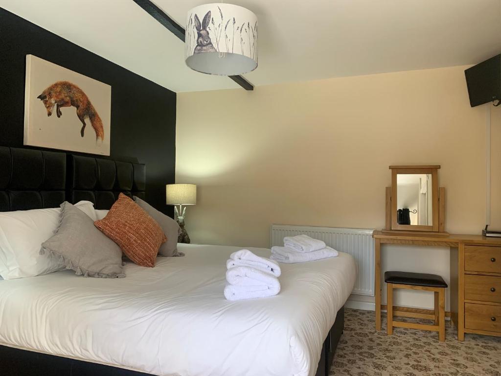 多切斯特纽因酒店 - 多尔切斯特的一间卧室配有带毛巾的床