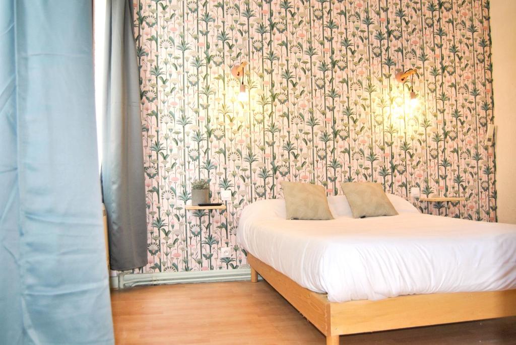 第戎图洛特酒店的一间卧室配有一张带花卉壁纸的床