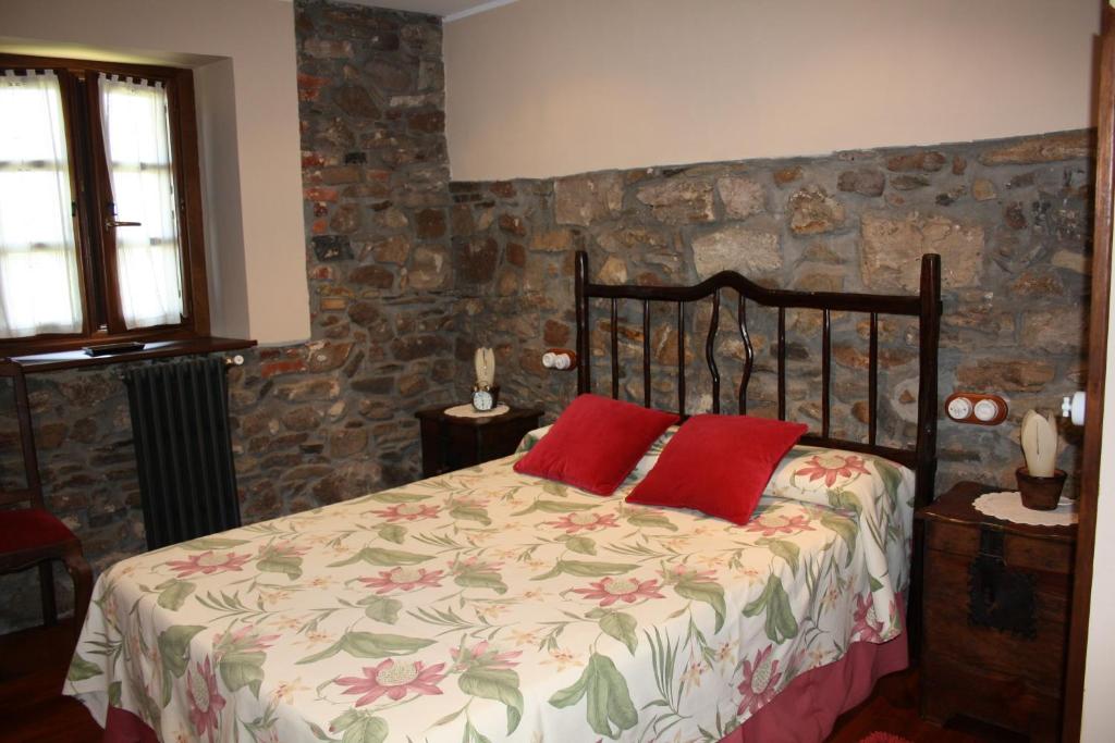 库迪列罗卡瑟纳贝尼托乡村民宿的一间卧室配有一张带两个红色枕头的床
