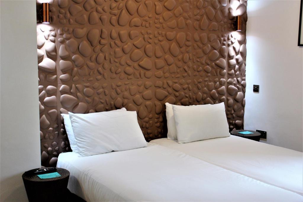 格拉茨克洛斯瑞欧司乔治公寓式酒店的一张带两个白色枕头和棕色床头板的床