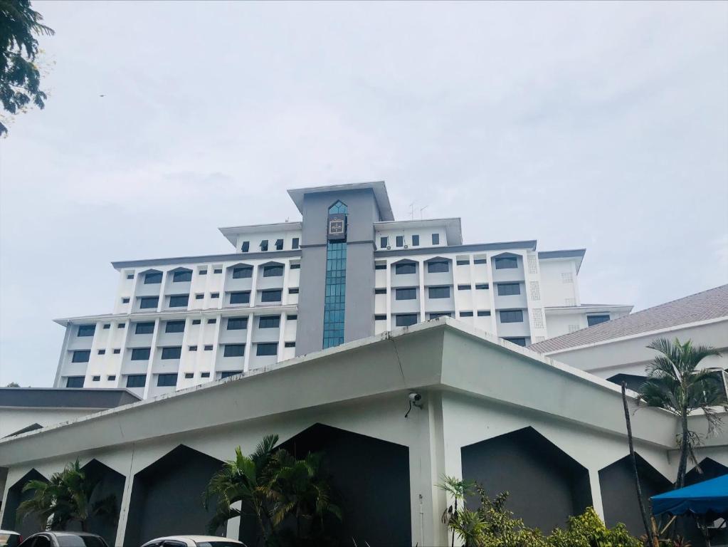 哥打京那巴鲁Raia Hotel Kota Kinabalu的一座白色的大建筑,顶部设有钟楼