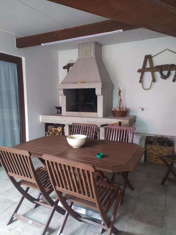 格罗韦O Pazo的带壁炉的客房内的一张木桌和椅子