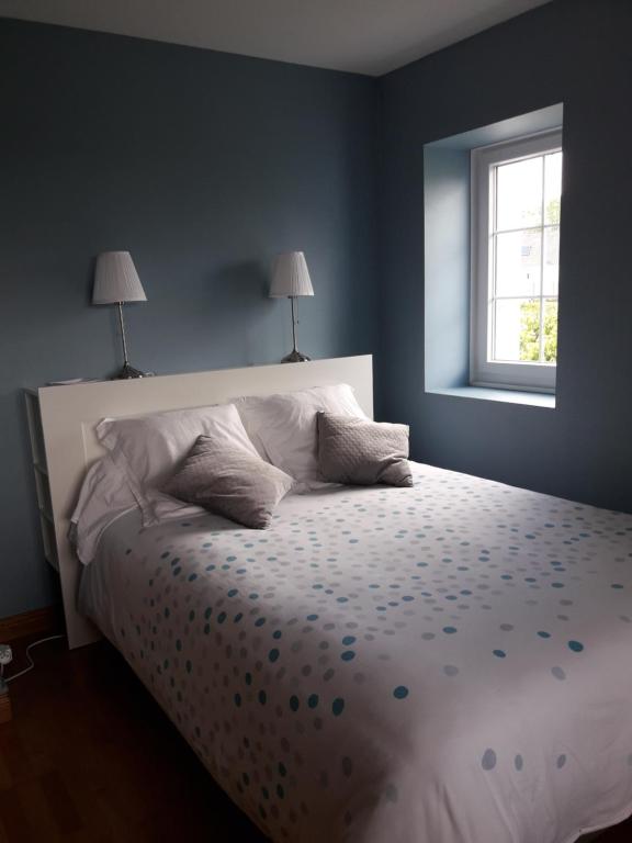 高伊斯瑙Chambre dans villa的一间卧室配有带两个枕头的床和窗户