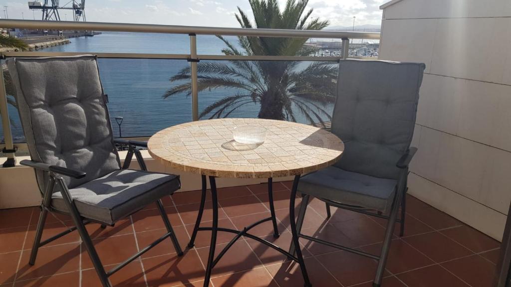 罗萨里奥港Ático La Marina的阳台配有一张桌子和两把椅子