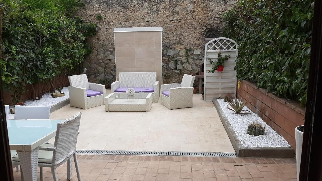 特罗佩阿Villa Oscar的庭院配有白色的椅子和桌子