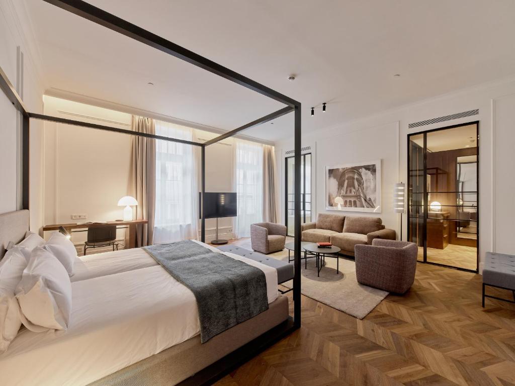 布达佩斯Kozmo Hotel Suites & Spa - Small Luxury Hotels of the World的一间带大床的卧室和一间客厅
