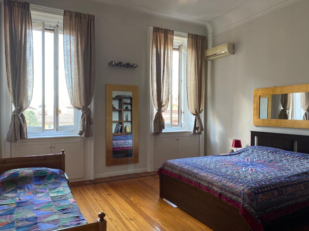 米兰Sant'Ambrogio with charme的一间卧室设有两张床、镜子和窗户。