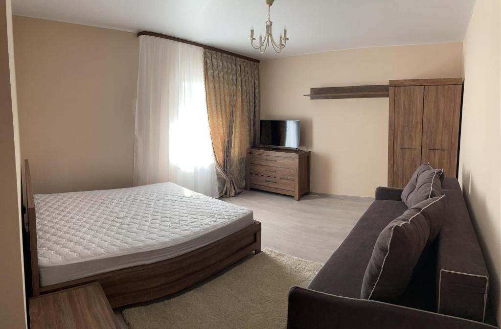 KopylovЗатишна однокімнатна квартира під Києвом的一间卧室配有一张床和一张沙发