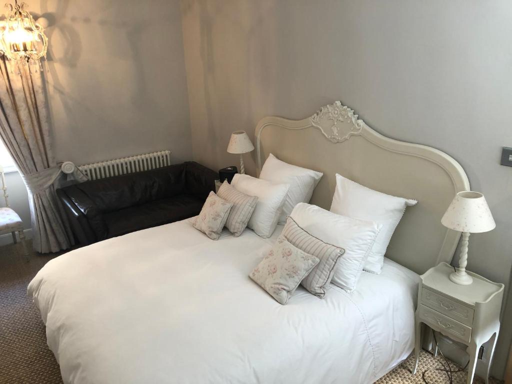 斯坦福德St Martins Apartment Stamford的卧室配有带枕头和沙发的白色床。