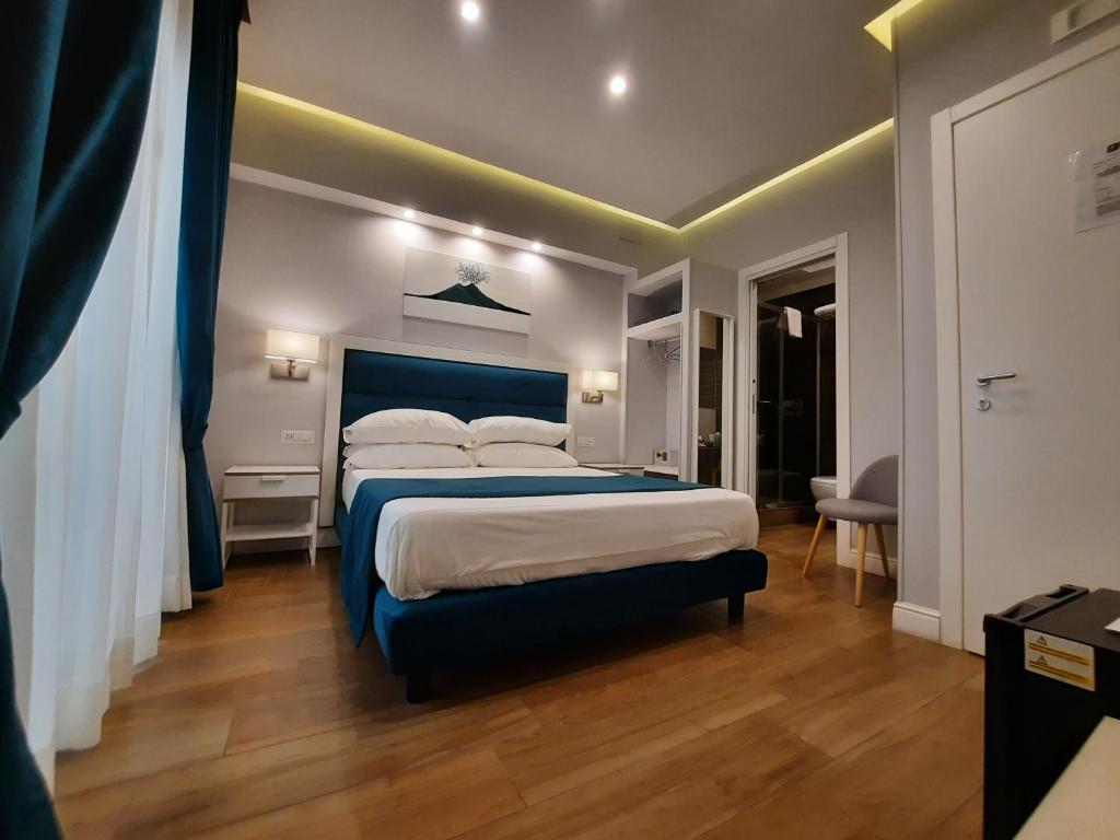 那不勒斯Gea suite的一间卧室配有一张大床和蓝色床头板