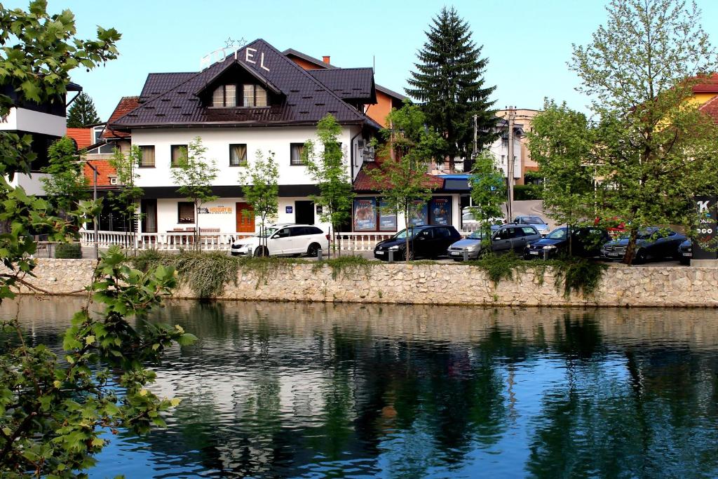 比哈奇Holiday In Bihać的河前有车的房屋