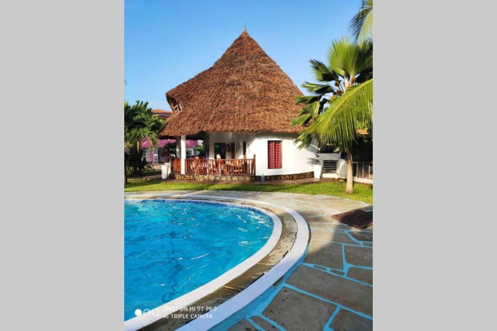 迪亚尼海滩Dadida‘s Pool Cottage的一座带游泳池和茅草屋顶的别墅