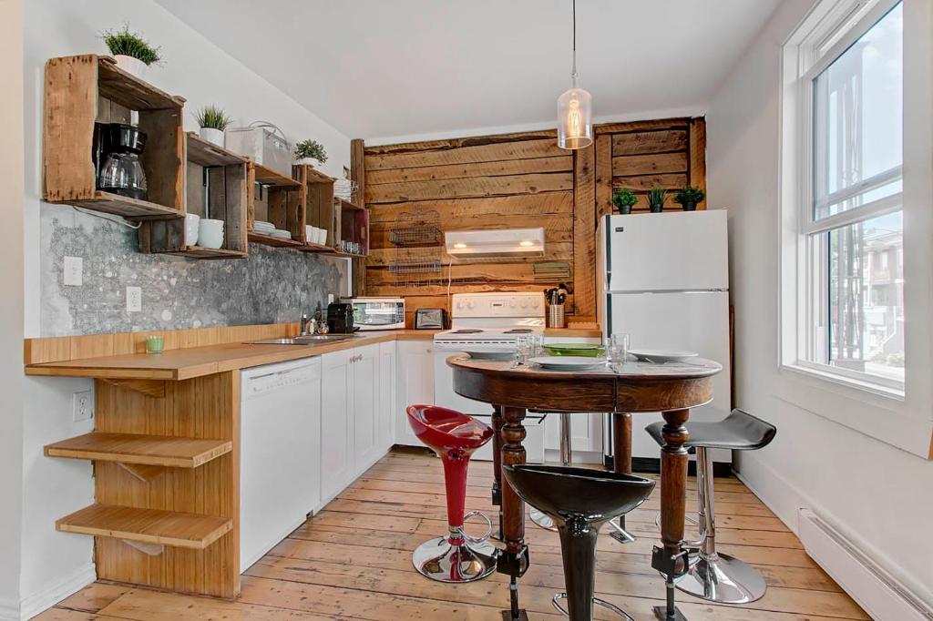 魁北克市Les Appartements du 790的厨房配有桌子和冰箱