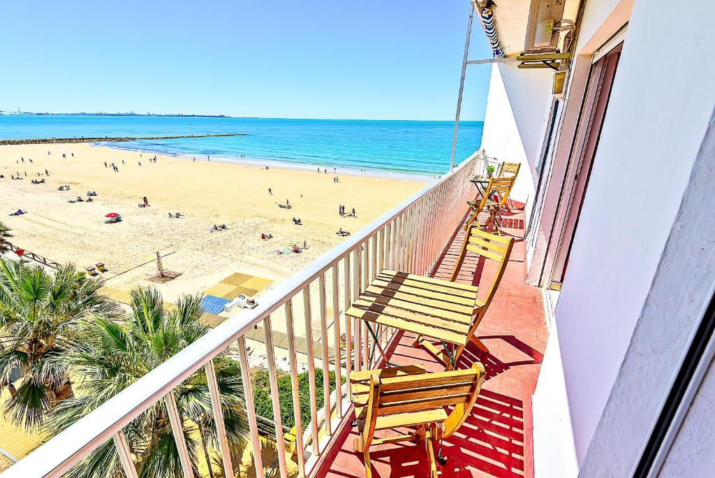 圣玛丽亚港En Playa Apartamento con Balcón, Wifi的一个带椅子的阳台,一个海滩和大海