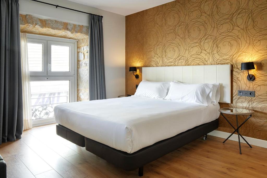 圣塞瓦斯蒂安Hotel Arrizul Beach的一间卧室设有一张大床和一个窗户。