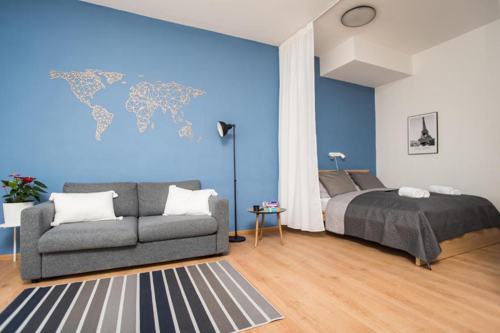 特伦钦Penzión Branecky的一间卧室配有床、沙发和蓝色的墙壁