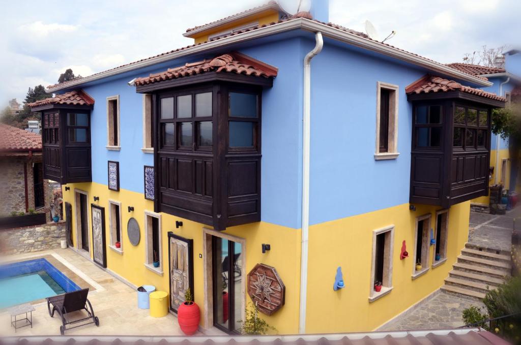 塞尔丘克Ayasoluk Hotel & Restaurant的蓝色和黄色的房屋,设有游泳池