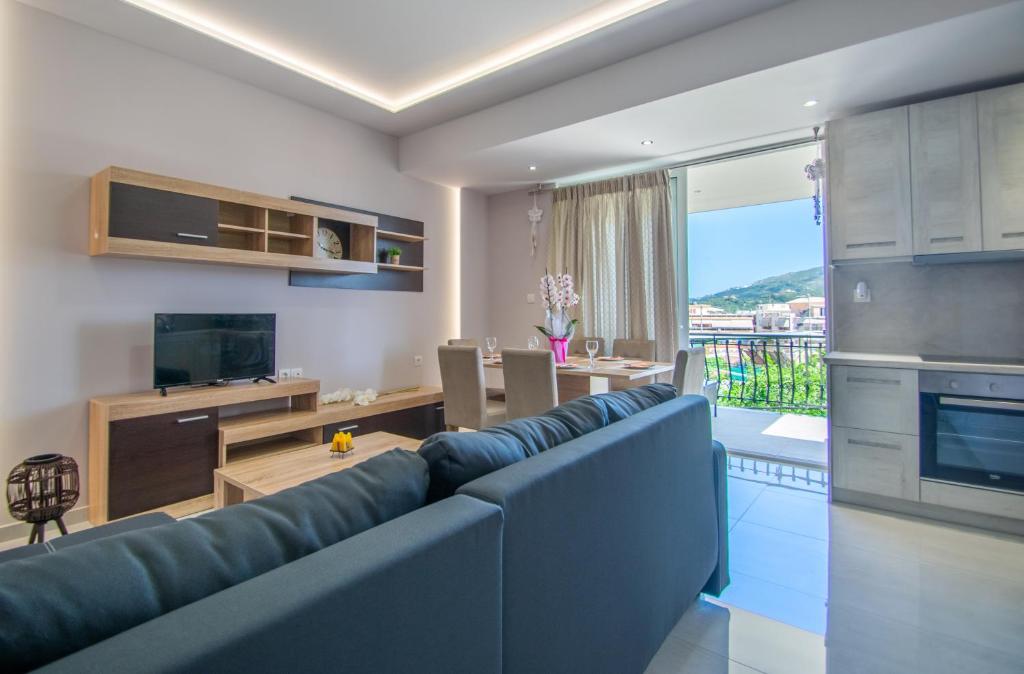 扎金索斯镇zakynthos town modern roof apartment的一间带蓝色沙发的客厅和一间厨房