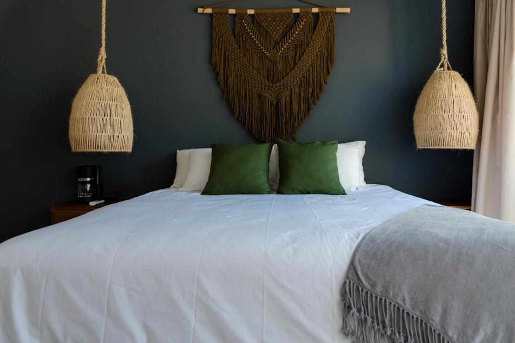 奥尔沃克斯岛Sanyama Holbox的卧室配有带绿色枕头的白色床