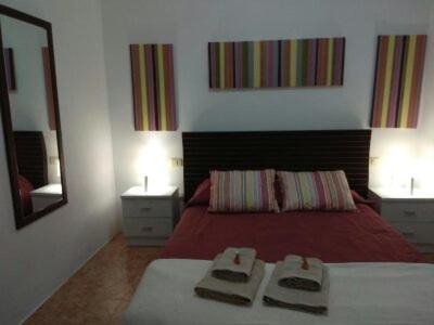 圣克鲁斯-德特内里费Casa Relajación的一间卧室配有红色的床和镜子