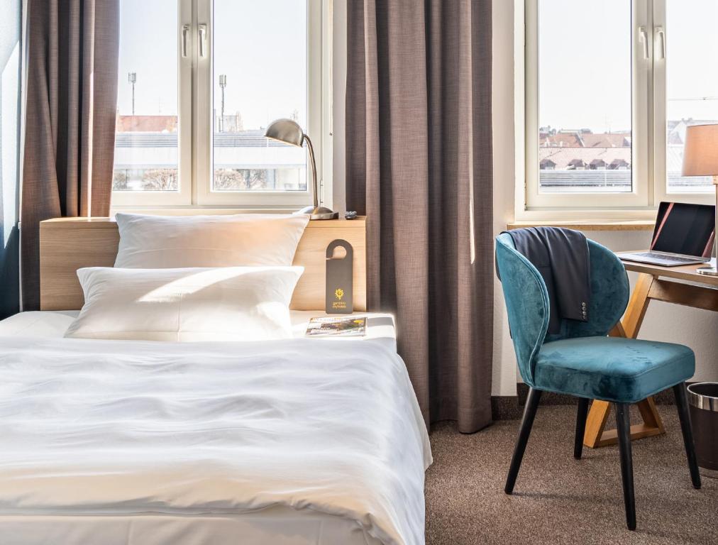 慕尼黑施塔胡斯酒店的酒店客房配有一张床、一张桌子和一把椅子。
