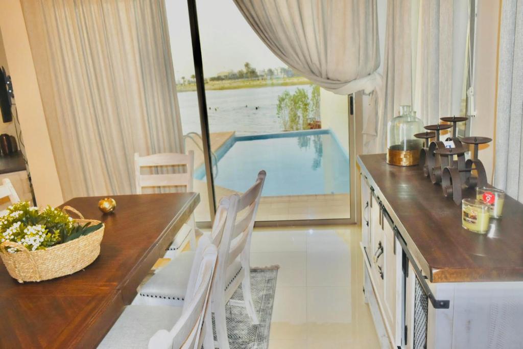 阿可贺巴Amwaj Resort For Families Only的一间带桌子和游泳池的用餐室
