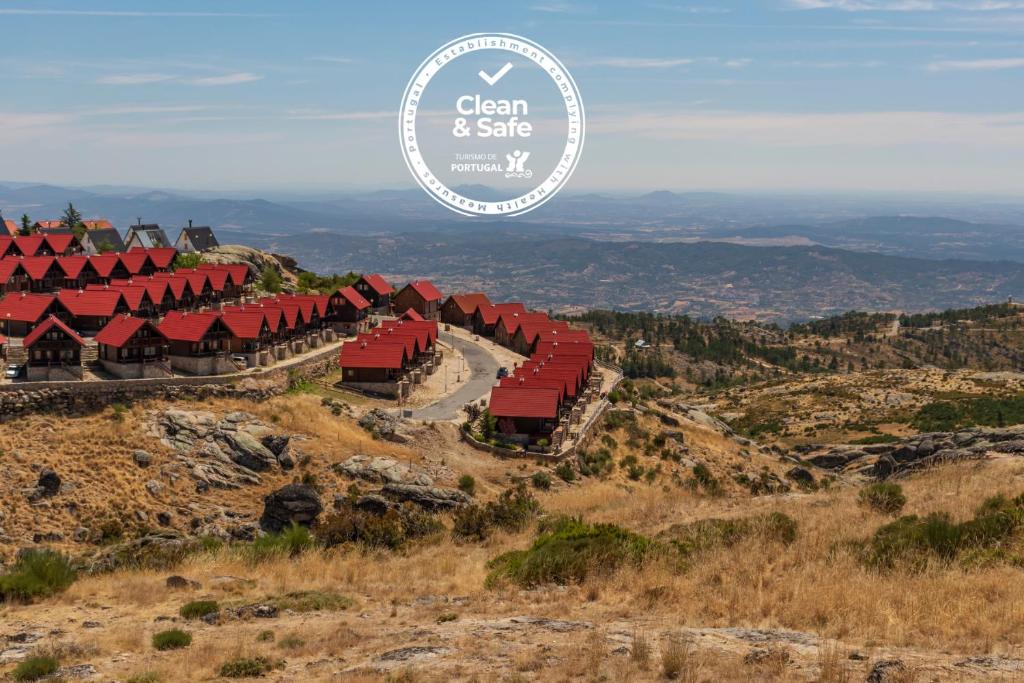 科维良Luna Chalets da Montanha - Serra da Estrela的山丘上红色建筑的山景