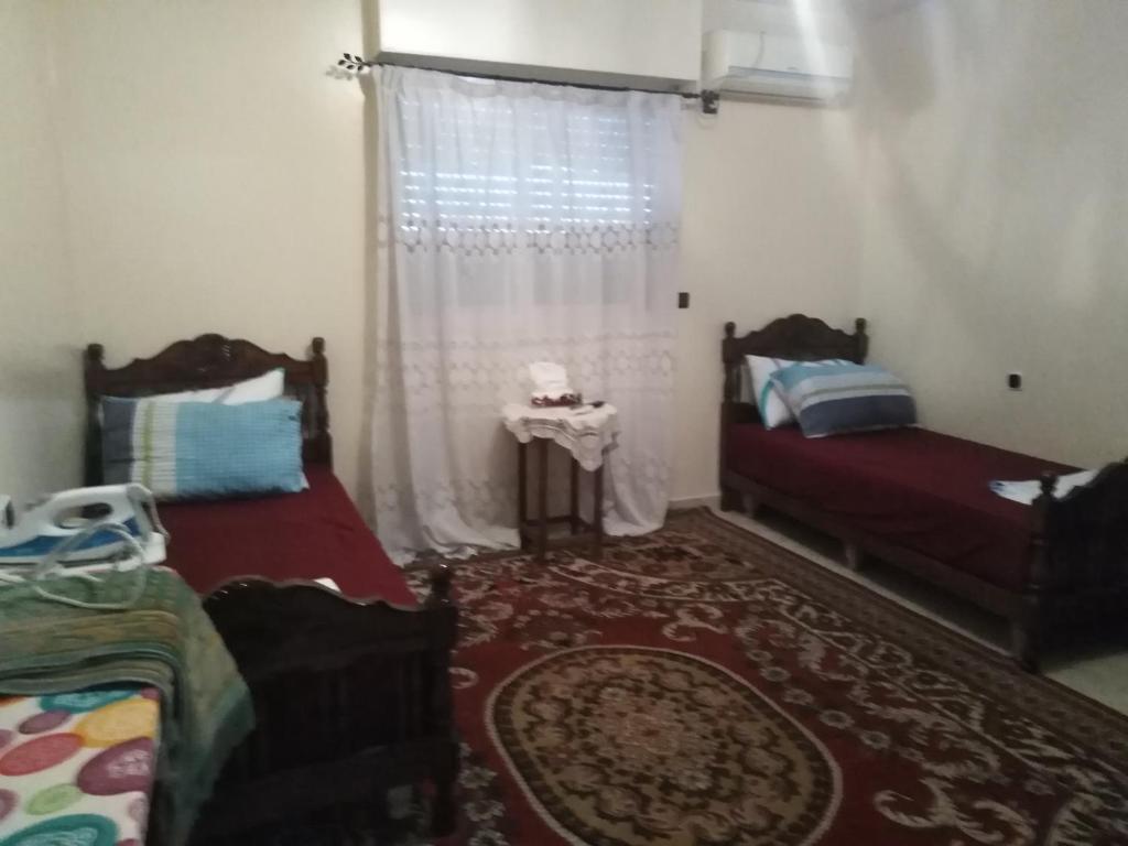 阿加迪尔Appartement au centre Agadir résidence privée的一间卧室设有两张床和窗户。