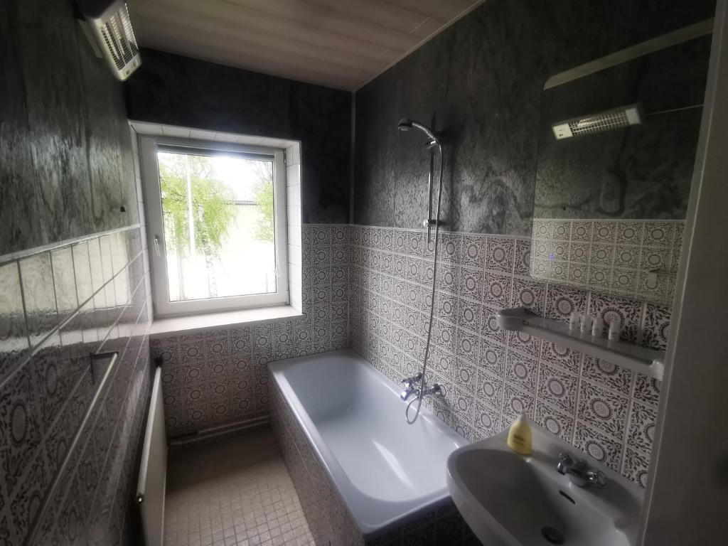 格明德Ferienwohnung Solebad的带浴缸、水槽和窗户的浴室