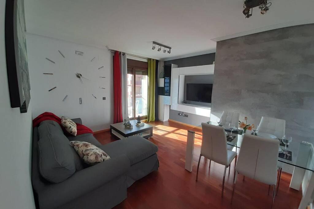 科尔多瓦Piso céntrico con piscina,parking y jacuzzi的客厅配有沙发和墙上的时钟