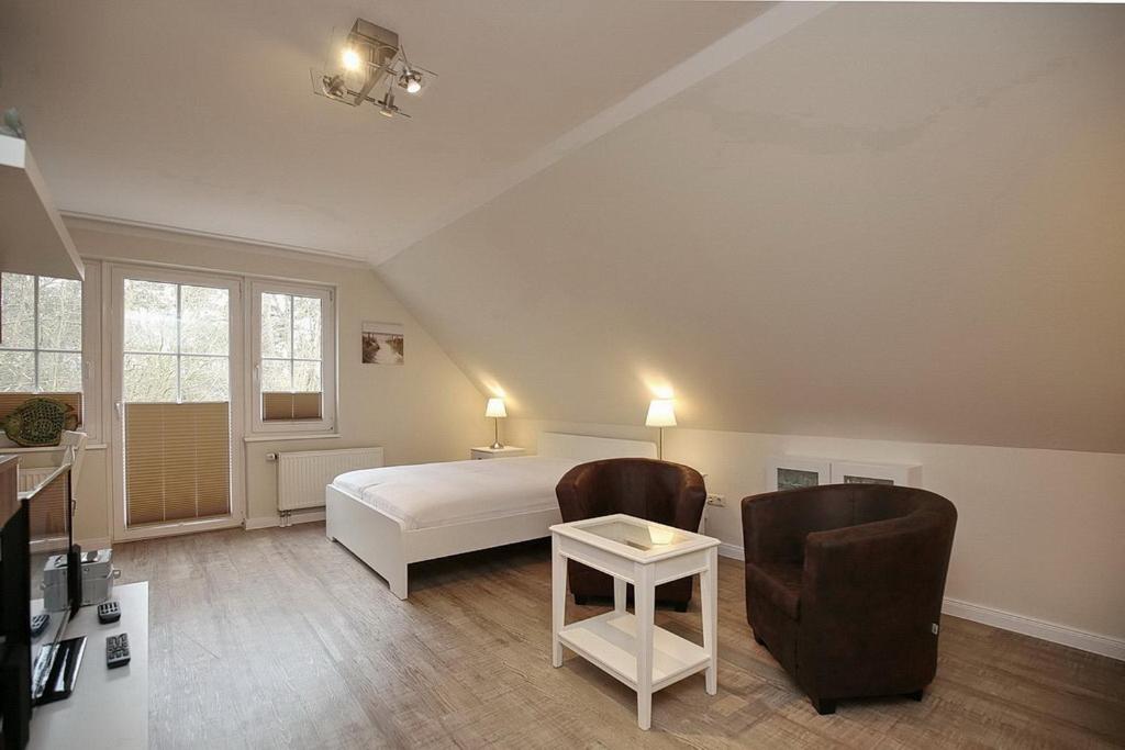 博尔滕哈根Strandvilla Krabbe Wohnung 14的一间卧室配有一张床、两把椅子和一张桌子