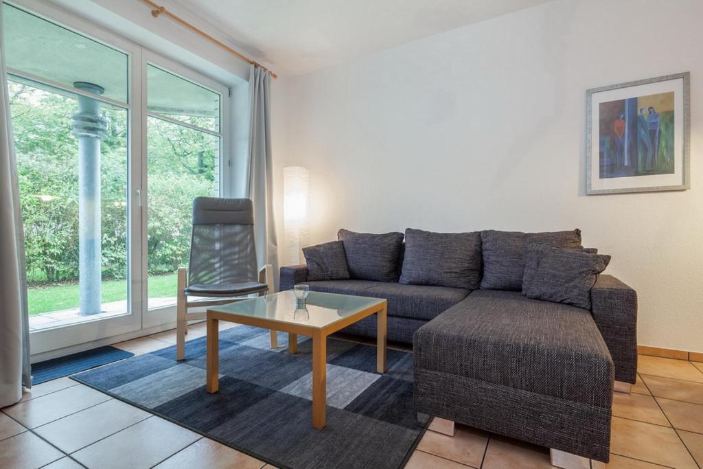 博尔滕哈根Dünenblick Wohnung 19的客厅配有沙发和桌子