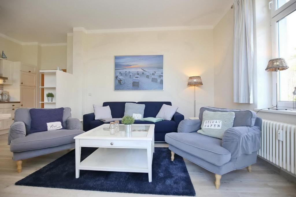 博尔滕哈根Villa Triton Wohnung 01的客厅配有2张蓝色的沙发和1张桌子