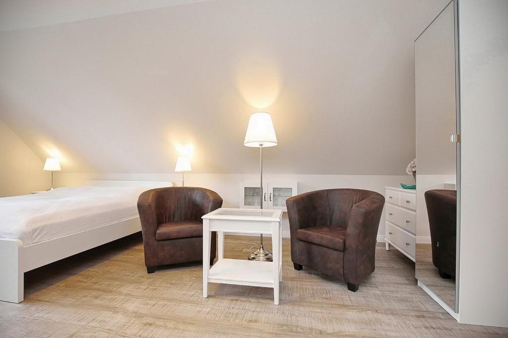 博尔滕哈根Strandvilla Krabbe Wohnung 13的一间卧室配有一张床、两把椅子和一张桌子
