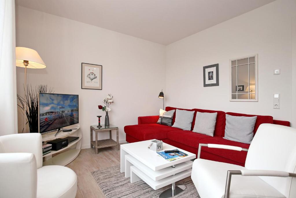 海利根达姆Residenz von Flotow Wohnung 14的客厅配有红色沙发和电视