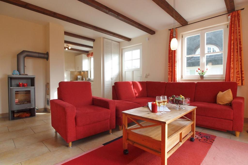 维滕贝克Ferienhaus Nanni的客厅配有红色的沙发和两把椅子