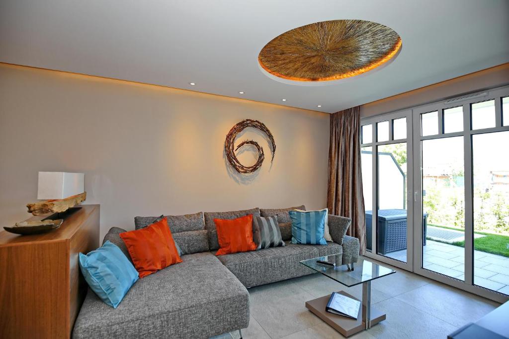 海利根达姆Linden-Palais Wohnung 01的客厅配有灰色沙发,提供橙色和蓝色枕头