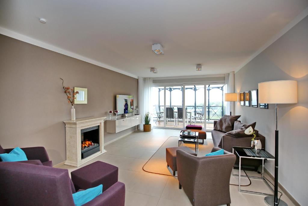 海利根达姆Linden-Palais Wohnung 37的客厅配有紫色椅子和壁炉
