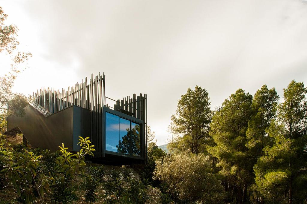 贝尼曼特利VIVOOD Landscape Hotel & Spa - Designed for Adults的一座树木茂密的山丘上的玻璃房子