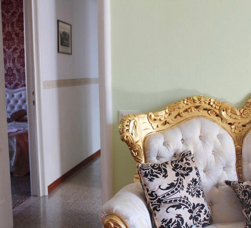 威尼斯The Golden Apartment的金色和白色的椅子,上面有枕头