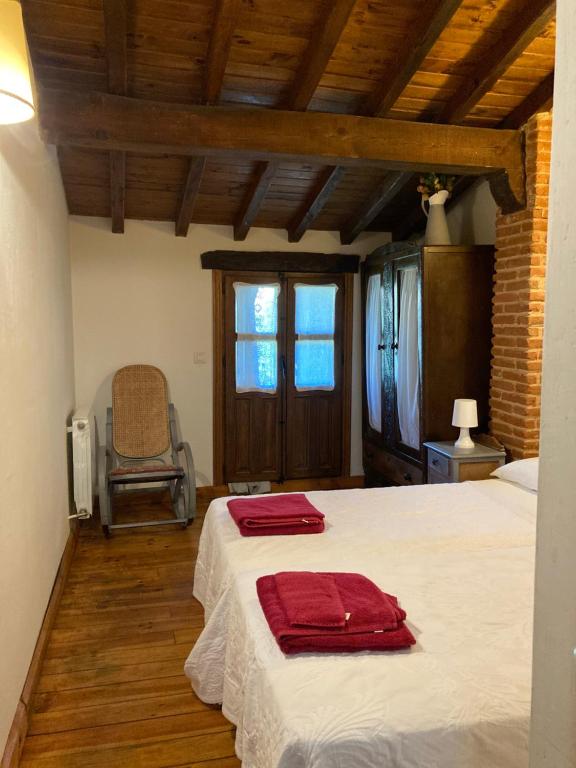 Villanueva del CondeCasa rural Adelaida的一间卧室配有一张带两个红色毛巾的床