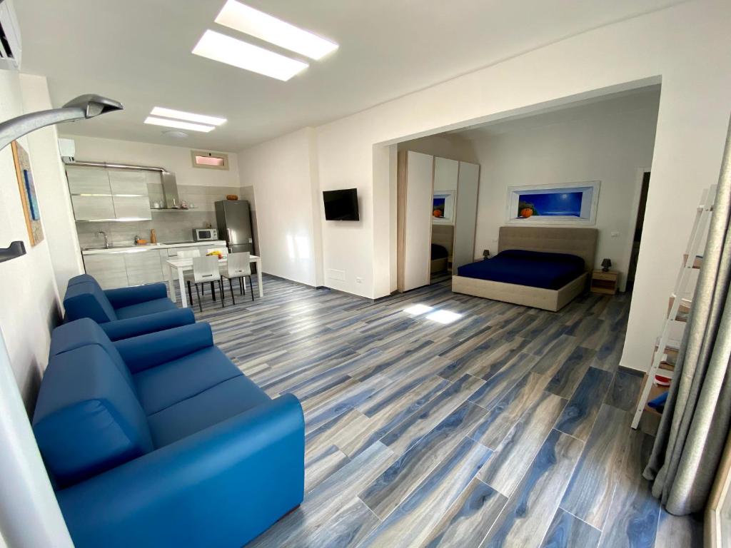费拉约港Appartamenti Acquazzurra的一间带蓝色沙发的客厅和一间卧室