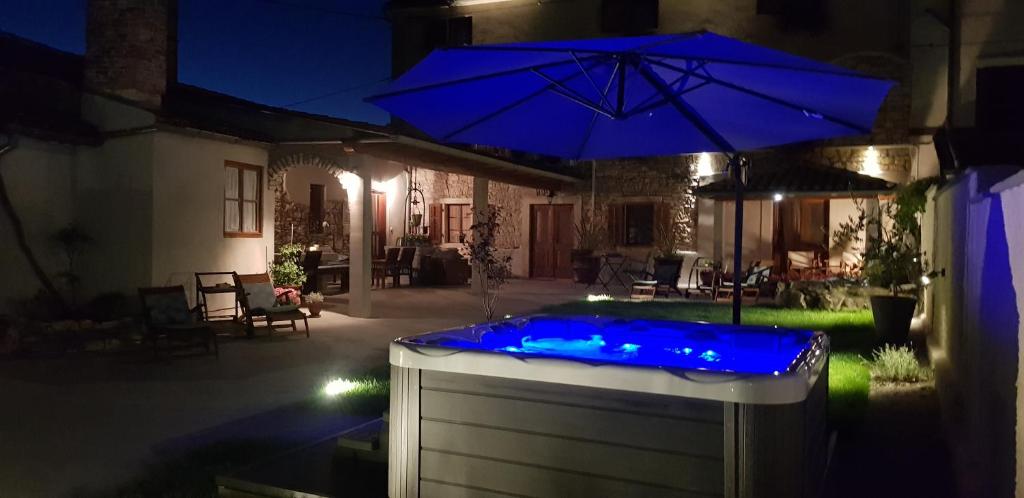 罗波里卡Rooms & Apartment STELIO的晚上在院子里设有一个蓝色灯光的热水浴缸