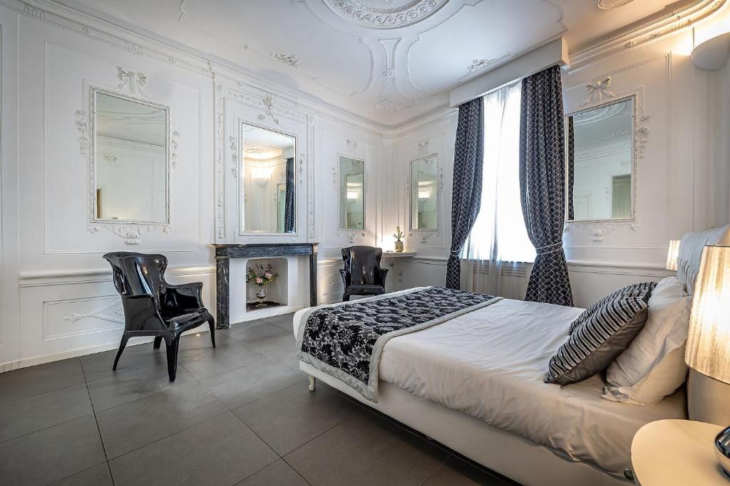 佛罗伦萨Boutique Hotel La Casa di Morfeo的一间卧室配有一张床和椅子,以及一个壁炉