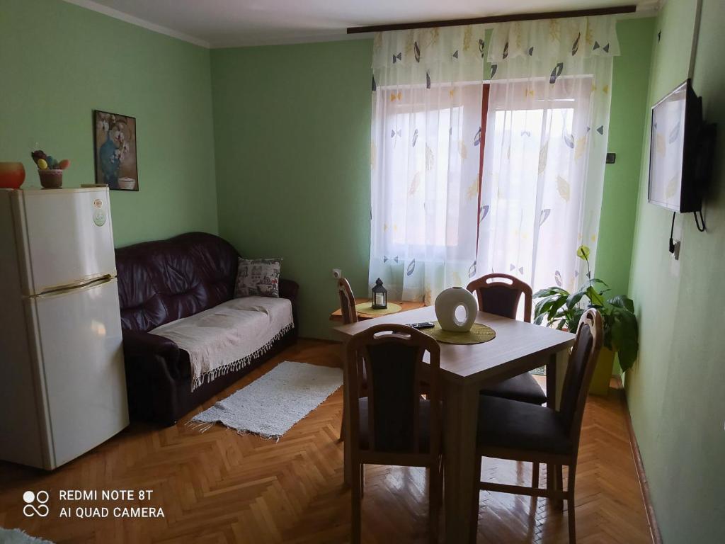 索科矿泉村Smestaj Gmitrovic的客厅配有桌子和冰箱